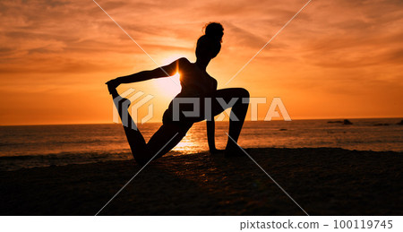 Meditation, yoga and silhouette of woman on beach at sunrise for exercise, training and pilates workout. Motivation, fitness and shadow of girl balance by ocean for sports, wellness and stretching 100119745