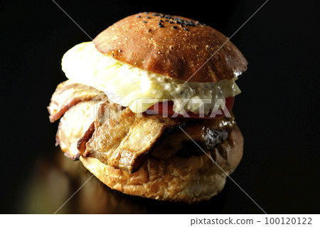 BLT Burger with bacon, lettuce and tomato with tartar sauce protruding in a black background BLT Burger with bacon, lettuce and tomato with tartar sauce protruding in a black background 100120122