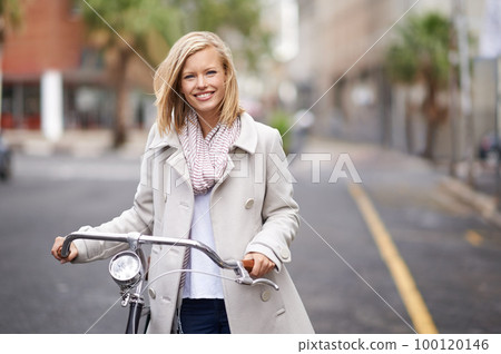 I go everywhere by bike. Shot of a young woman in the street with a bicycle. 100120146