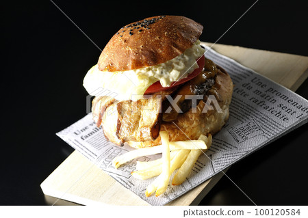 BLT 漢堡和薯條，配培根、生菜和番茄，黑色背景中突出塔塔醬 100120584