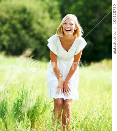 Nothing beats a good laugh. Cute young woman laughing while standing in a field outdoors. Nothing beats a good laugh. Cute young woman laughing while standing in a field outdoors. 100120720