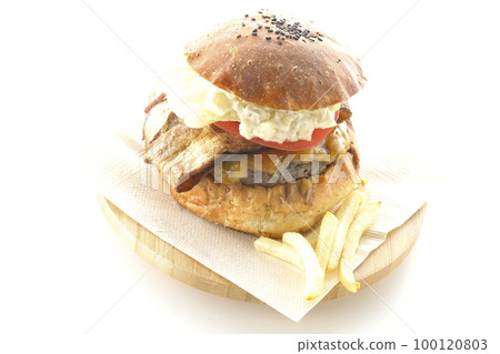 BLT burger with tartar sauce protruding and bacon, lettuce and tomato sandwiched between potatoes and a white background 100120803