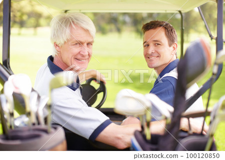 Golfing buddies. Golfing companions on the golf course in a golf cart. 100120850
