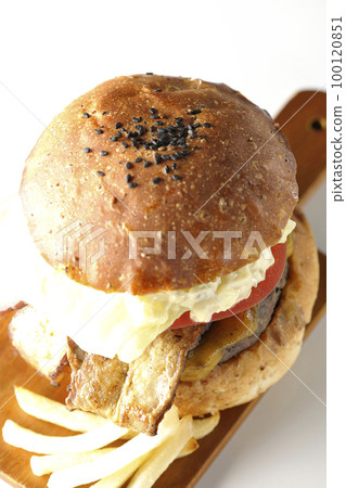 BLT burger with tartar sauce protruding and bacon, lettuce and tomato sandwiched between potatoes and a white background 100120851