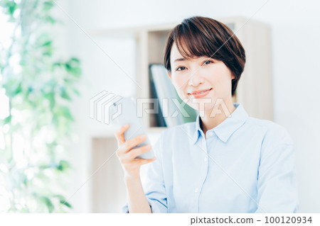 Middle woman operating a smartphone Middle woman operating a smartphone 100120934