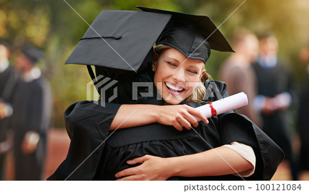 We are finally here. Two college graduates hugging one another in congratulations. 100121084
