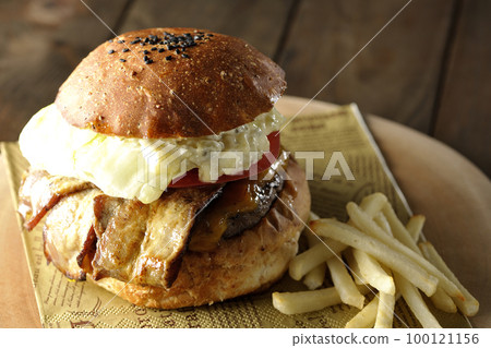 BLT Burger with tartar sauce protruding and bacon, lettuce and tomato sandwiched between fries 100121156