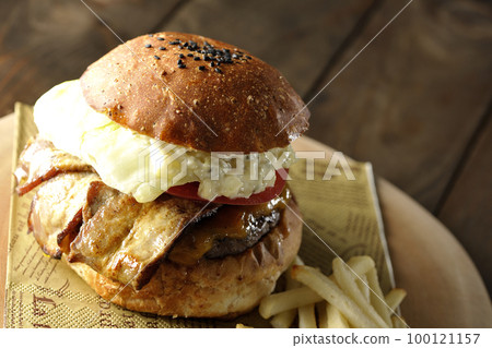 BLT Burger with tartar sauce protruding and bacon, lettuce and tomato sandwiched between fries 100121157