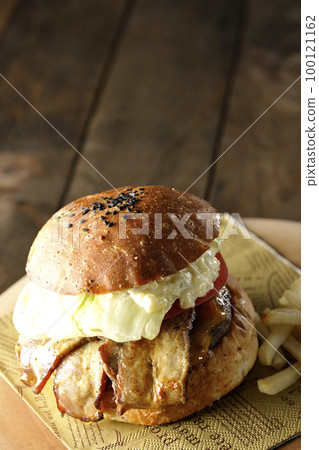 BLT Burger with tartar sauce protruding and bacon, lettuce and tomato sandwiched between fries 100121162