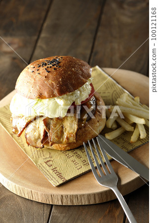 BLT Burger with tartar sauce protruding and bacon, lettuce and tomato sandwiched between fries 100121168