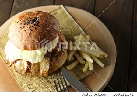 BLT Burger with tartar sauce protruding and bacon, lettuce and tomato sandwiched between fries 100121172