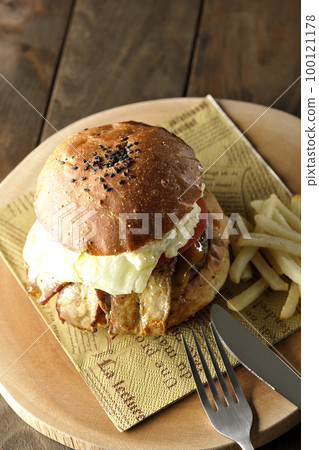 BLT Burger with tartar sauce protruding and bacon, lettuce and tomato sandwiched between fries 100121178