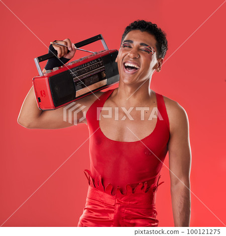 Happy, man and boombox radio in studio for gay, pride and vogue aesthetic with retro 80s tech by red background. Lgbtq model, vintage fashion and music with happiness, listening and comic laughing 100121275