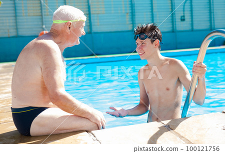 sports grandfather and grandson communicate in swimming pool sports grandfather and grandson communicate in swimming pool 100121756