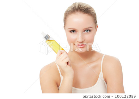 This really does the trick. A pretty young woman holding a bottle of perfume while isolated on a white background. 100122089