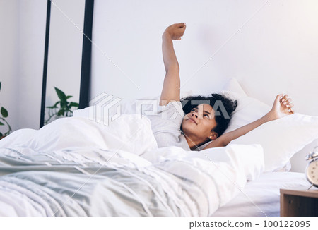 Morning stretch, wake up and black woman in bed with peace feeling relax in a bedroom. Home, day start and calm young person in a house stretching arms on a lazy weekend ready for sleep or nap Morning stretch, wake up and black woman in bed with peace feeling relax in a bedroom. Home, day start and calm young person in a house stretching arms on a lazy weekend ready for sleep or nap 100122095