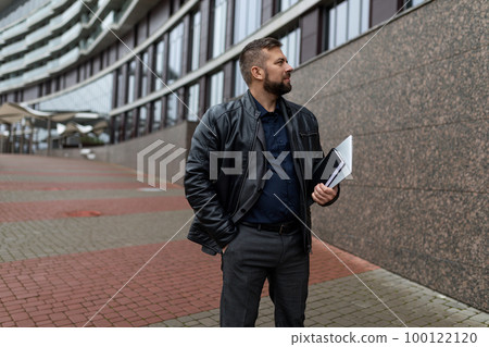 successful man with documents of an architect on the background of a dark building successful man with documents of an architect on the background of a dark building 100122120