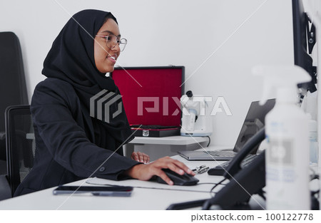 Optometry, consulting and Muslim woman on a computer for research, healthcare and analytics. Ophthalmology, check and doctor reading information, eye results and analysis of medicare on a pc 100122778