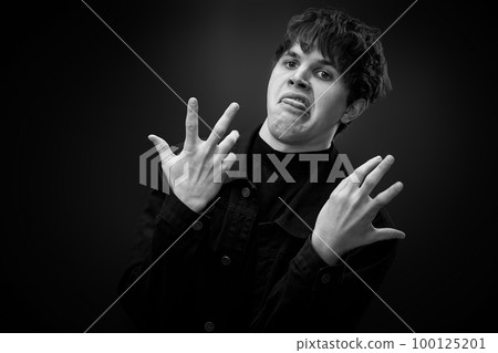 crazy young man with awesome hairdo grimacing 100125201
