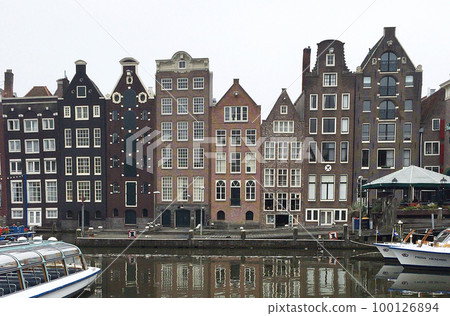 A beautiful cityscape with long and homogeneous buildings along the canals of Amsterdam A beautiful cityscape with long and homogeneous buildings along the canals of Amsterdam 100126894