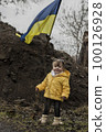 Little girl in front of defensive structures of Ukrainian army. War in Ukraine. Children and war concept. Support for Ukraine. Stop war. Humanitarian disaster concept. Ukrainian flag 100126928