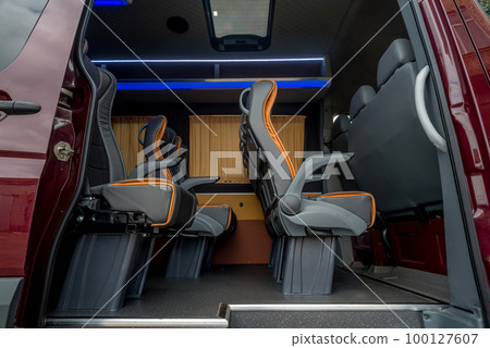 Comfortable interior of a passenger bus with soft seats 100127607