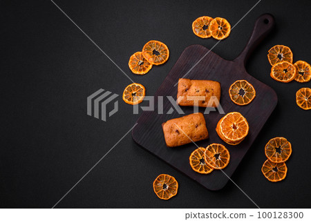 Delicious chocolate muffins and dried round shaped slices of tangerine 100128300