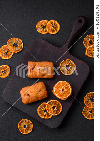 Delicious chocolate muffins and dried round shaped slices of tangerine 100128301