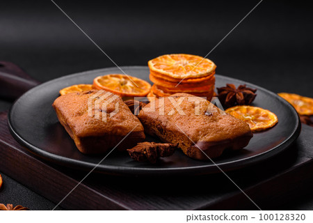 Delicious chocolate muffins and dried round shaped slices of tangerine 100128320