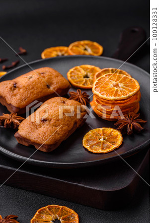 Delicious chocolate muffins and dried round shaped slices of tangerine Delicious chocolate muffins and dried round shaped slices of tangerine 100128331