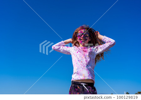 Young european girl celebrating holy festival on a blue sky background Young european girl celebrating holy festival on a blue sky background 100129819