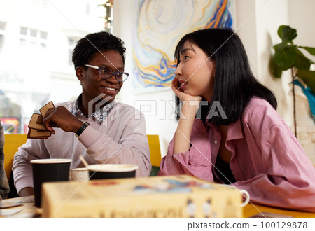 Cute mixed race couple of teenagers enjoying milkshake at cafeteria, first date Cute mixed race couple of teenagers enjoying milkshake at cafeteria, first date 100129878