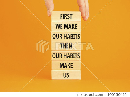 Our habits symbol. Concept words First we make our habits then our habits make us on wooden blocks. Beautiful orange background. Copy space. Businessman hand. Motivational business our habits concept. Our habits symbol. Concept words First we make our habits then our habits make us on wooden blocks. Beautiful orange background. Copy space. Businessman hand. Motivational business our habits concept. 100130411