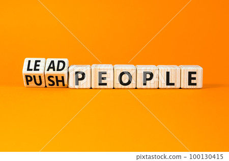 Lead or push people symbol. Concept word Lead people and Push people on wooden cubes. Beautiful orange table orange background. Business Energy or hunger crisis concept. Copy space. 100130415