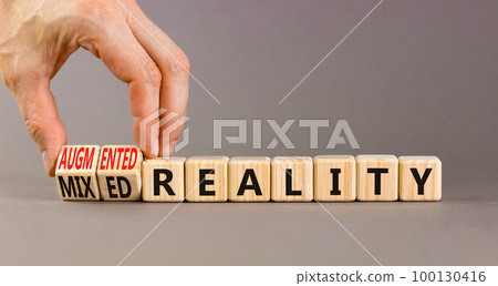 Augmented or mixed reality symbol. Concept words Augmented reality Mixed reality on wooden cubes. Beautiful grey background. Businessman hand. Business augmented or mixed reality concept. Copy space. 100130416