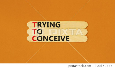 TTC trying to conceive symbol. Concept words TTC trying to conceive on wooden stick on a beautiful orange table orange background. Medical and TTC trying to conceive concept. Copy space. TTC trying to conceive symbol. Concept words TTC trying to conceive on wooden stick on a beautiful orange table orange background. Medical and TTC trying to conceive concept. Copy space. 100130477