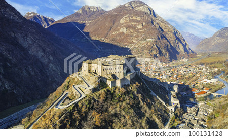 Italy .Famous medieval castles of valle d'Aosta - impressive Bard fort surrounded by Alps mountains. aerial drone view Italy .Famous medieval castles of valle d'Aosta - impressive Bard fort surrounded by Alps mountains. aerial drone view 100131428