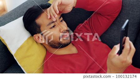 Glitch, mistake and man texting on sofa, shocked by bad news, scam alert or a breakup text. Confused, unhappy and worry with young male surprised by app message, feeling puzzled and nervous in home 100132174