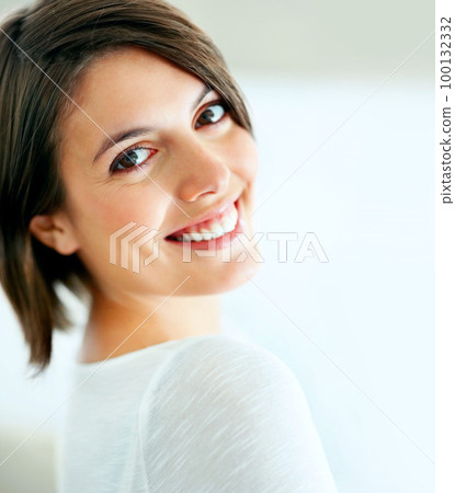 Candid and content. A beautiful woman smiling candidly at the camera - closeup. 100132332