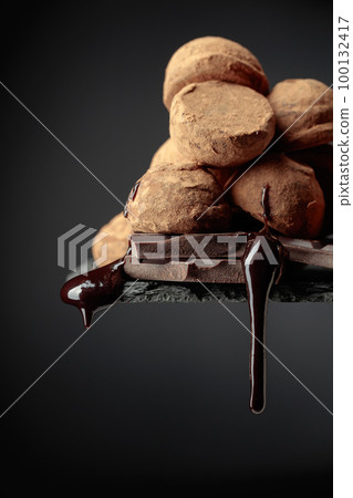Chocolate truffles and falling drops of chocolate sauce. 100132417