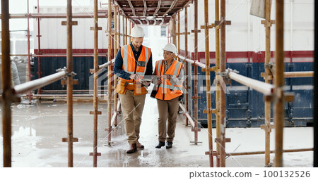 Construction worker, working together and conversation with tablet, communication and construction business. Engineer, job site with man and woman talking, collaboration and building trade. 100132526