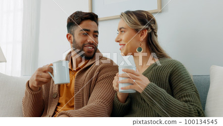 Movie, coffee and couple watching tv or streaming an online series via a subscription for fun entertainment at home. Relaxing, smile and happy woman enjoying a film together on a sofa with partner 100134545