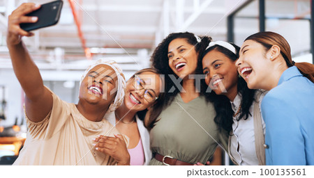 Business women, team and funny selfie with phone for social media, collaboration or startup success together. Female, group and diversity workers taking picture, smartphone or silly friends in office 100135561