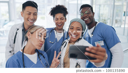 Doctors, team and selfie with diversity and health group, happiness with collaboration and smartphone photography. Medical professional, happy in picture and people in medicine with peace hand sign 100135890