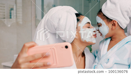 Beauty, skincare and facial with mother and girl and selfie in bathroom for health, spa and wellness. Luxury, product and mask on face with mom and child in family home for happy, peace and relax 100136076