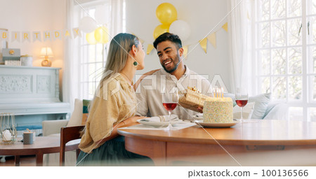 Gift, dinner and couple talking about birthday, anniversary or celebration at a dining room table in house. Happy, smile and young man and woman speaking about present, gratitude and love with food 100136566