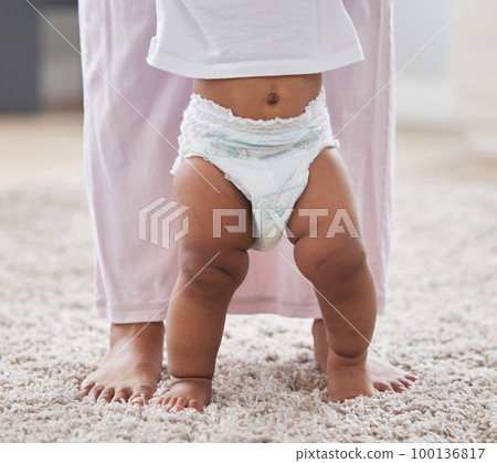Baby legs, learning and walking with mother, support and first steps of healthy body development. Closeup mom teaching child to walk, balance and feet on carpet for growth, milestone and motor skills 100136817