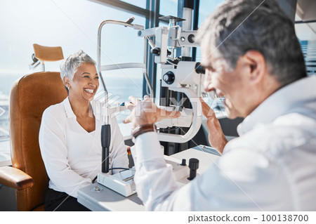 Eye doctor, machine or happy woman consulting for help with eyesight at optometrist in an optical assessment. Optician talking or asking senior customer info testing for vision, iris or retina health Eye doctor, machine or happy woman consulting for help with eyesight at optometrist in an optical assessment. Optician talking or asking senior customer info testing for vision, iris or retina health 100138700