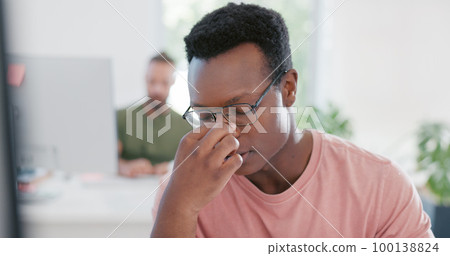 Stress, anxiety and mental health with a business black man removing his glasses while suffering from a headache at work. Burnout, frustration and migraine with a male employee working in his office 100138824