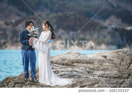 Bride and groom having fun in the blue sea 100139187